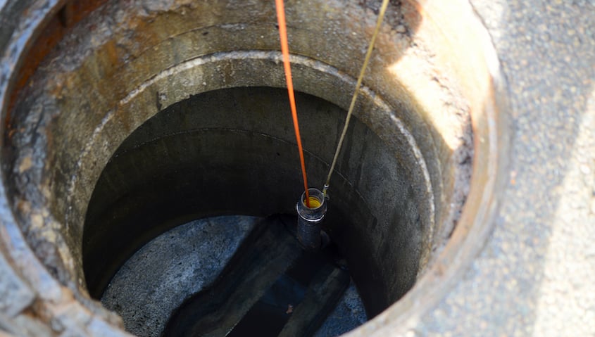 A camera is lowered into a city sewer line using a cable with a specific ingress protection (IP) rating.